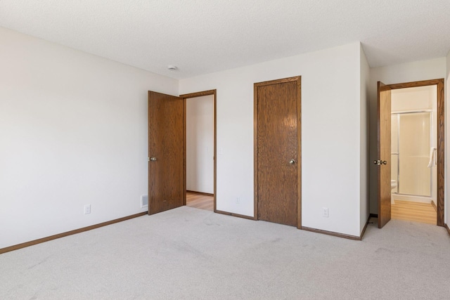 unfurnished bedroom with carpet flooring, baseboards, a closet, and a textured ceiling