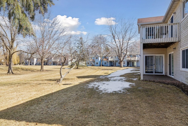 view of yard featuring a residential view and a balcony