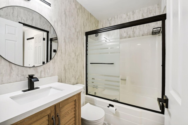 full bathroom with enclosed tub / shower combo, vanity, and toilet