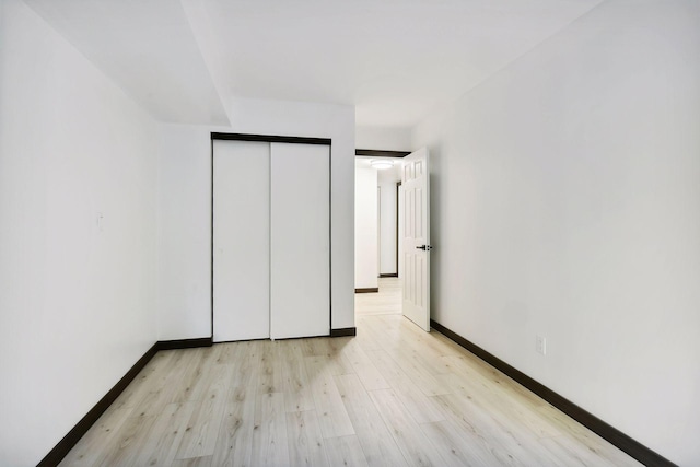 unfurnished bedroom with light hardwood / wood-style floors and a closet