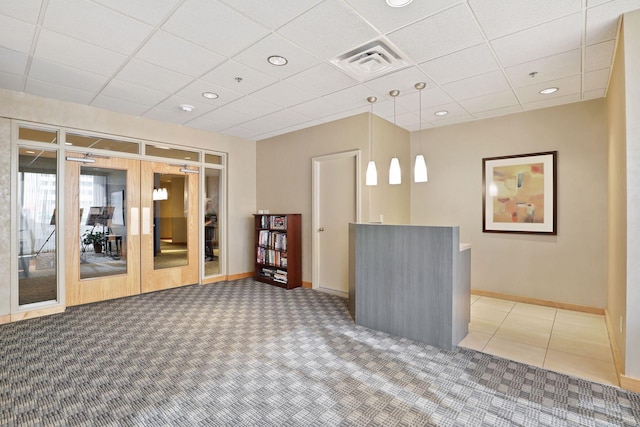 interior space featuring french doors and a drop ceiling