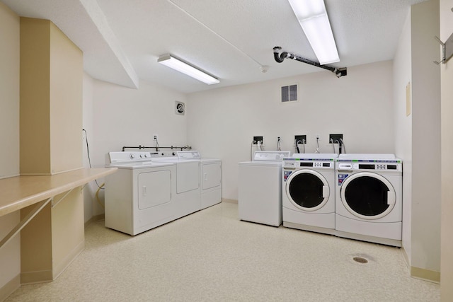 laundry area featuring washer and clothes dryer and a textured ceiling