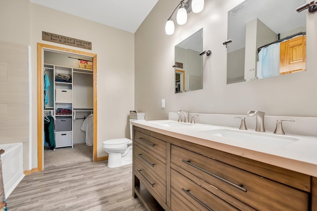 full bathroom featuring vanity, plus walk in shower, wood-type flooring, and toilet