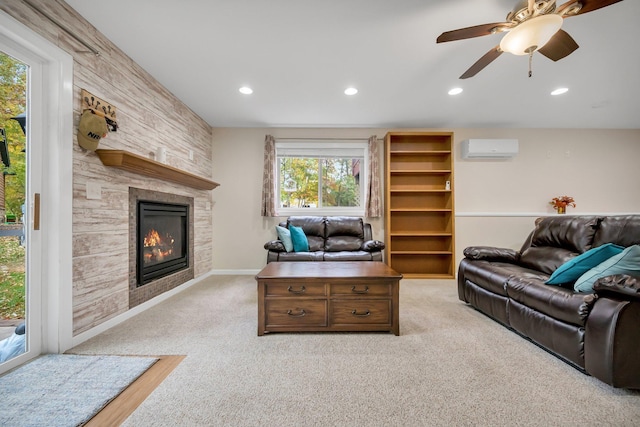 carpeted living room featuring a fireplace, a wall unit AC, and ceiling fan