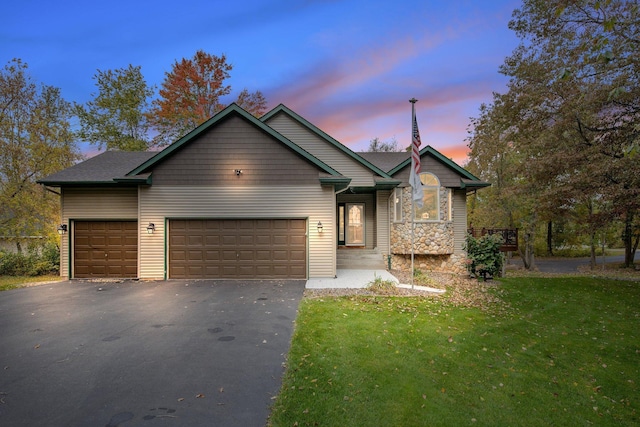 view of front of house with a garage and a lawn