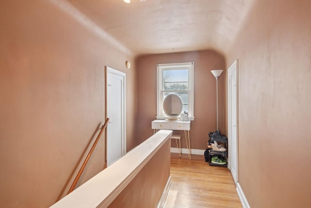 corridor with lofted ceiling and light hardwood / wood-style floors