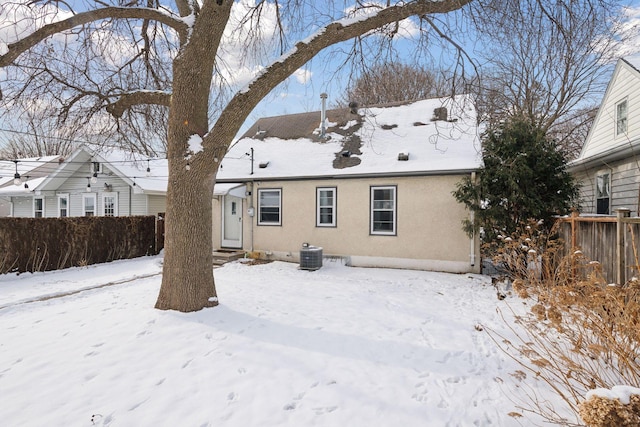 snow covered property with central AC