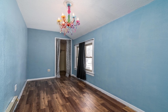 109 3rd St E, Ada, MN 56510 - empty room with a baseboard radiator, a chandelier, vaulted ceiling, wood finished floors, and baseboards