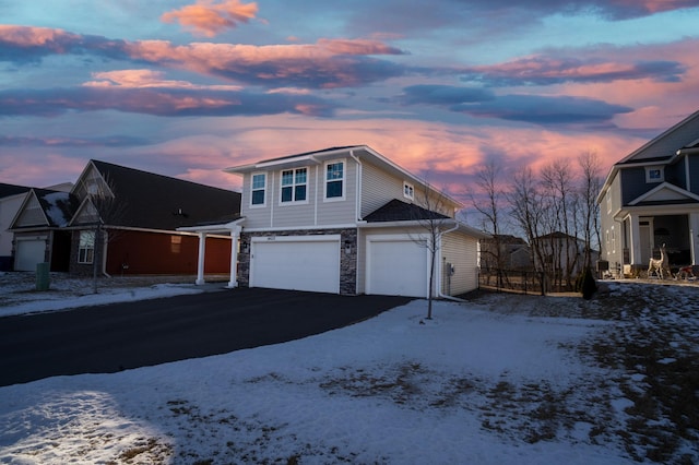 snow covered property with a garage