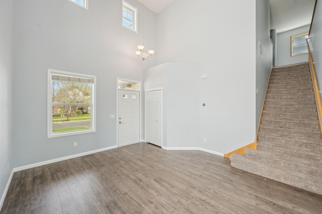 6789 Troy Ln N, Maple Grove, MN 55311 - entryway featuring stairs, wood finished floors, a chandelier, baseboards, and a towering ceiling