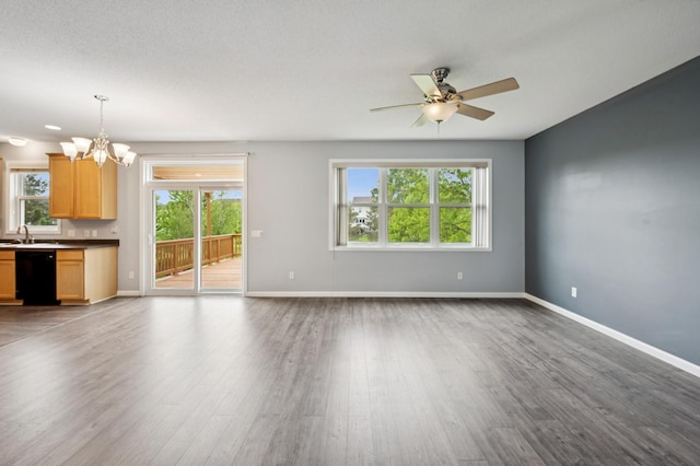 6789 Troy Ln N, Maple Grove, MN 55311 - unfurnished living room with a chandelier, wood finished floors, ceiling fan, and baseboards