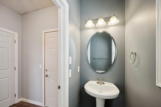 6789 Troy Ln N, Maple Grove, MN 55311 - bathroom featuring wood finished floors, baseboards, and a sink