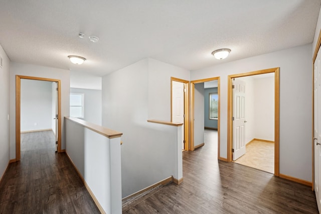 6789 Troy Ln N, Maple Grove, MN 55311 - hall with an upstairs landing, dark wood-type flooring, a textured ceiling, and baseboards
