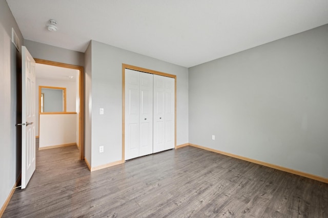 6789 Troy Ln N, Maple Grove, MN 55311 - unfurnished bedroom featuring wood finished floors, baseboards, and a closet