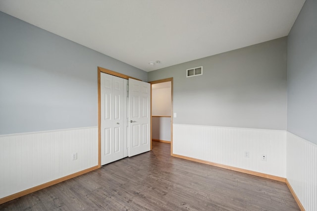 6789 Troy Ln N, Maple Grove, MN 55311 - unfurnished bedroom with wainscoting, wood finished floors, baseboards, and a closet