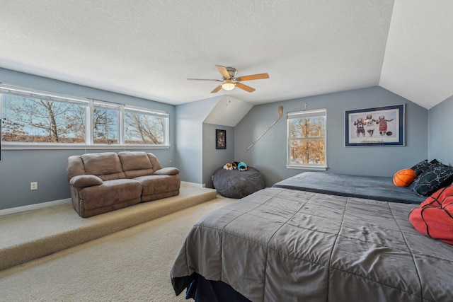 carpeted bedroom with vaulted ceiling, ceiling fan, and a textured ceiling