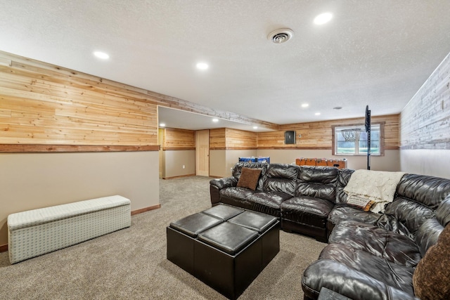 carpeted living room featuring a textured ceiling and wood walls