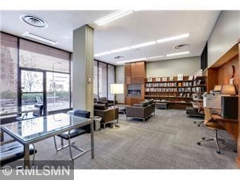 office area with light carpet and expansive windows