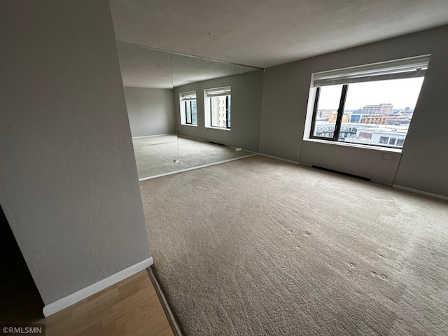 spare room with carpet and baseboards