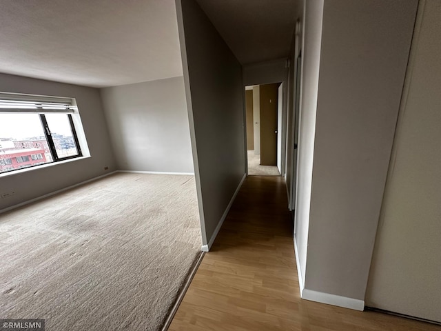 corridor featuring wood finished floors and baseboards