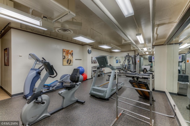 exercise room with baseboards and visible vents