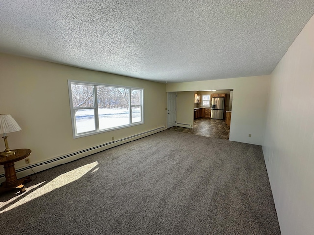 unfurnished living room with a baseboard heating unit, a textured ceiling, carpet, and a baseboard radiator