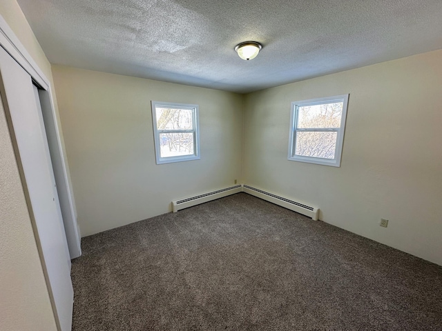 unfurnished bedroom featuring carpet, multiple windows, and a textured ceiling