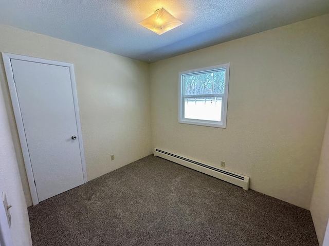 carpeted spare room featuring a textured ceiling and baseboard heating