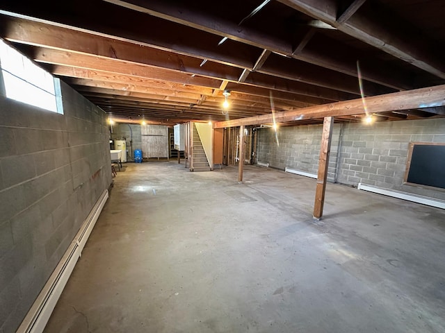 below grade area featuring a baseboard radiator and electric water heater