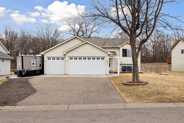 view of front of house with driveway, a garage, and fence