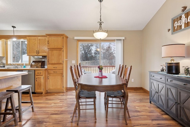 dining space featuring light wood-type flooring and baseboards