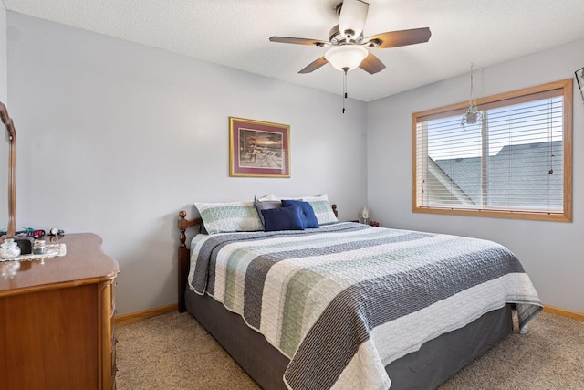 bedroom featuring baseboards, ceiling fan, a textured ceiling, and light colored carpet