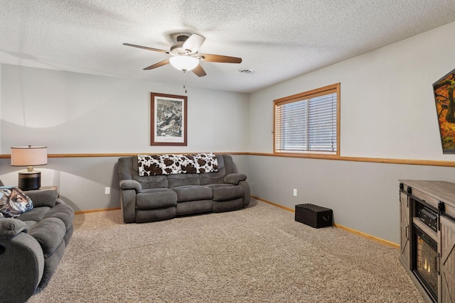 living area with carpet, baseboards, and a textured ceiling