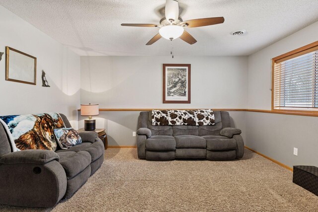 living room featuring carpet floors, visible vents, a textured ceiling, and baseboards