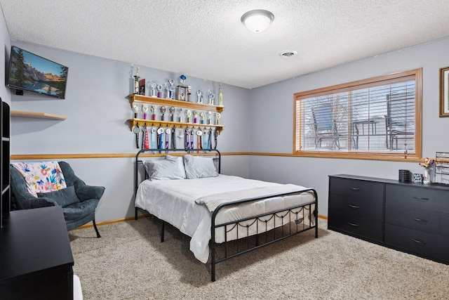 bedroom with a textured ceiling, carpet, visible vents, and baseboards