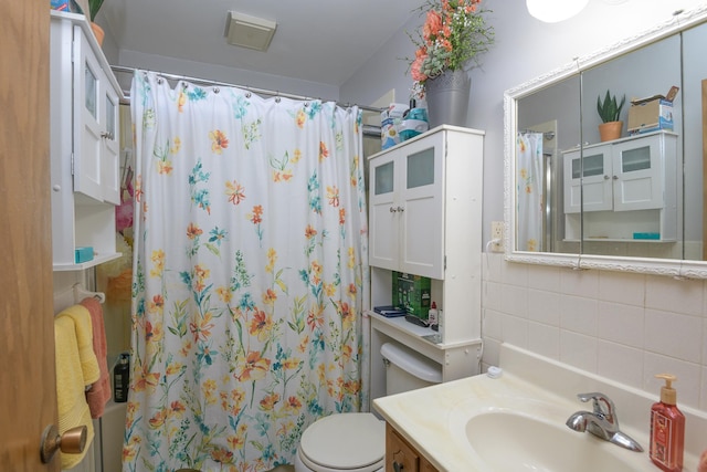 bathroom with vanity, backsplash, and toilet