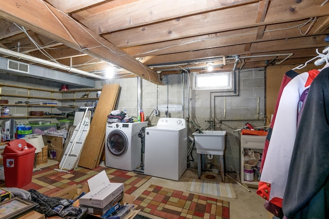 clothes washing area featuring sink and washing machine and clothes dryer