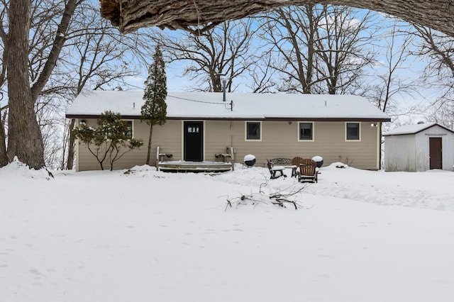 snow covered property featuring a storage shed