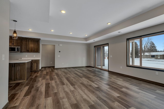 unfurnished living room featuring dark hardwood / wood-style floors and a raised ceiling