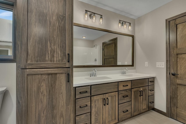 bathroom with tile patterned flooring, vanity, and walk in shower