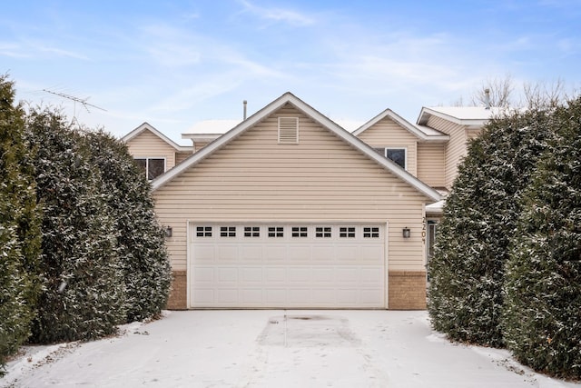 view of front facade featuring a garage, concrete driveway, and brick siding