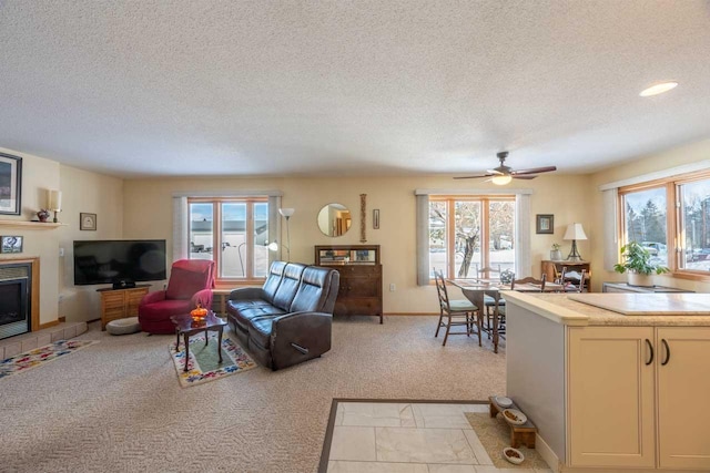 living room featuring light colored carpet, a tile fireplace, and a healthy amount of sunlight