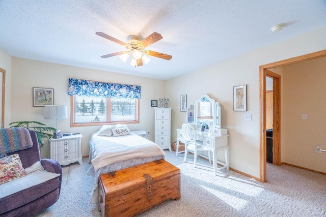 carpeted bedroom featuring ceiling fan and a textured ceiling