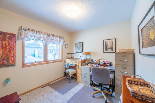 carpeted office featuring a textured ceiling