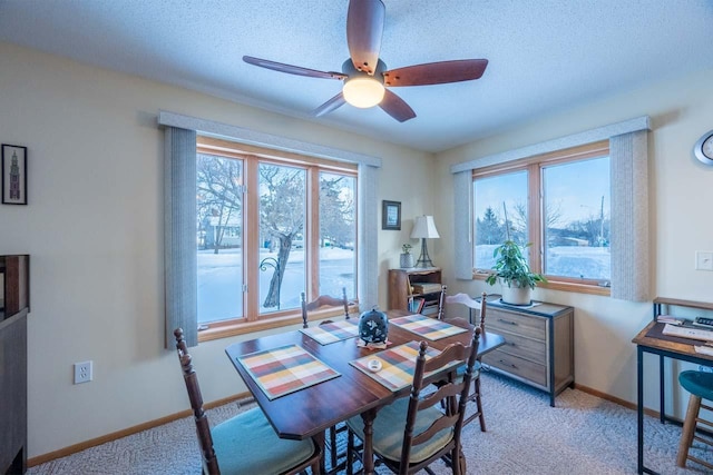 dining room with ceiling fan, light colored carpet, and a textured ceiling