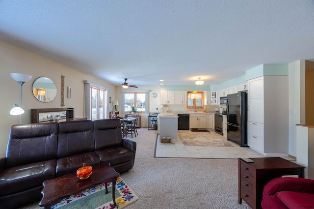 carpeted living room with ceiling fan and a textured ceiling