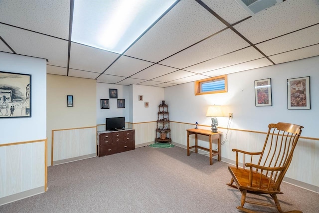 sitting room with a drop ceiling and carpet flooring