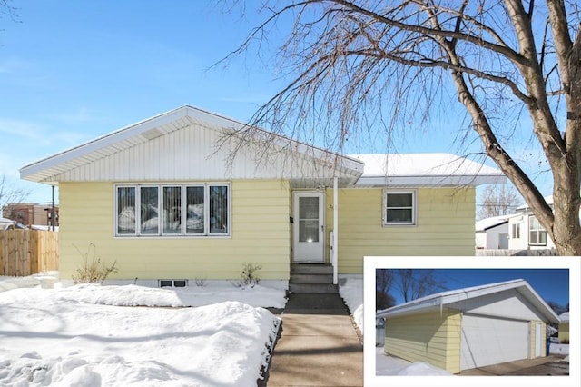 view of front of home featuring entry steps, fence, and a garage