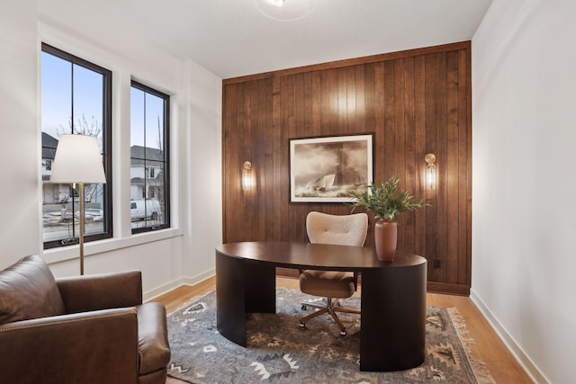 office featuring hardwood / wood-style floors and wood walls