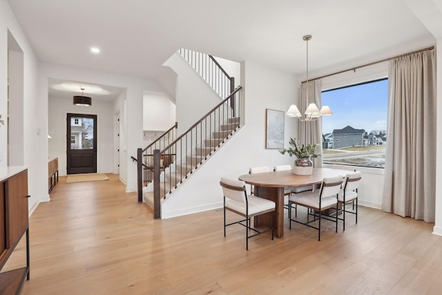 dining area featuring a notable chandelier, plenty of natural light, and light wood-type flooring